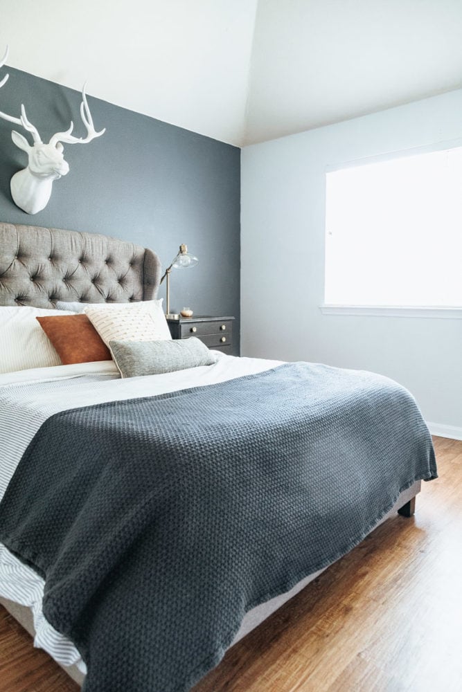 a master bedroom with blue and white walls and wood flooring