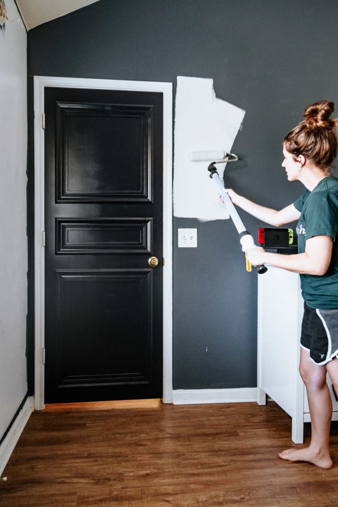 woman painting a wall white