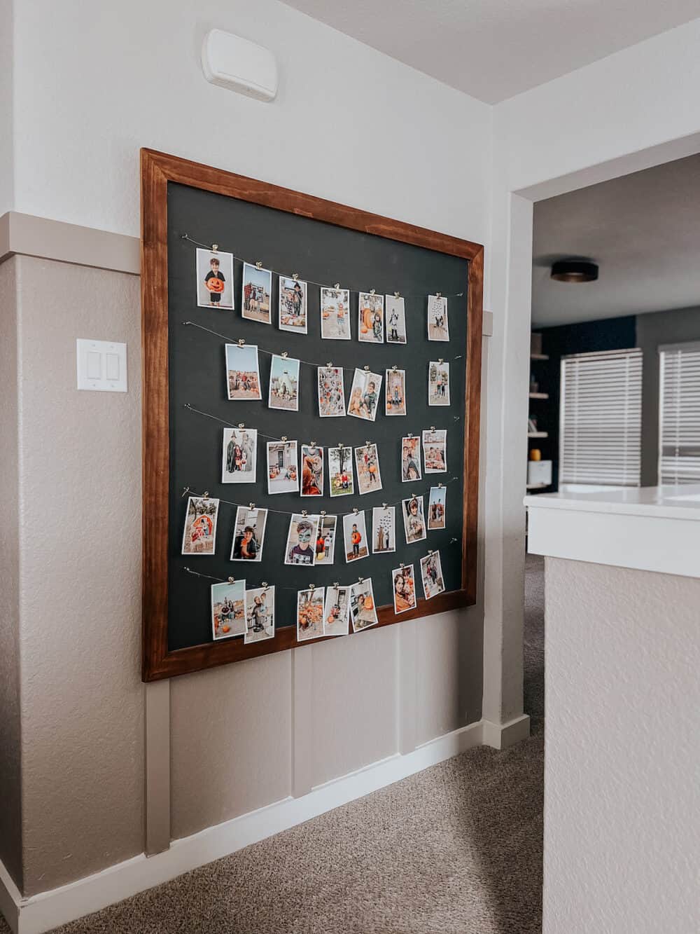 a family picture wall display with wires and clips