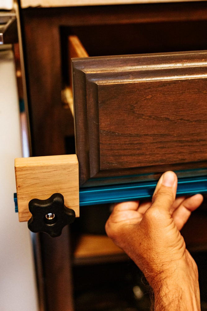 man using Rockler jig to install cabinet hardware