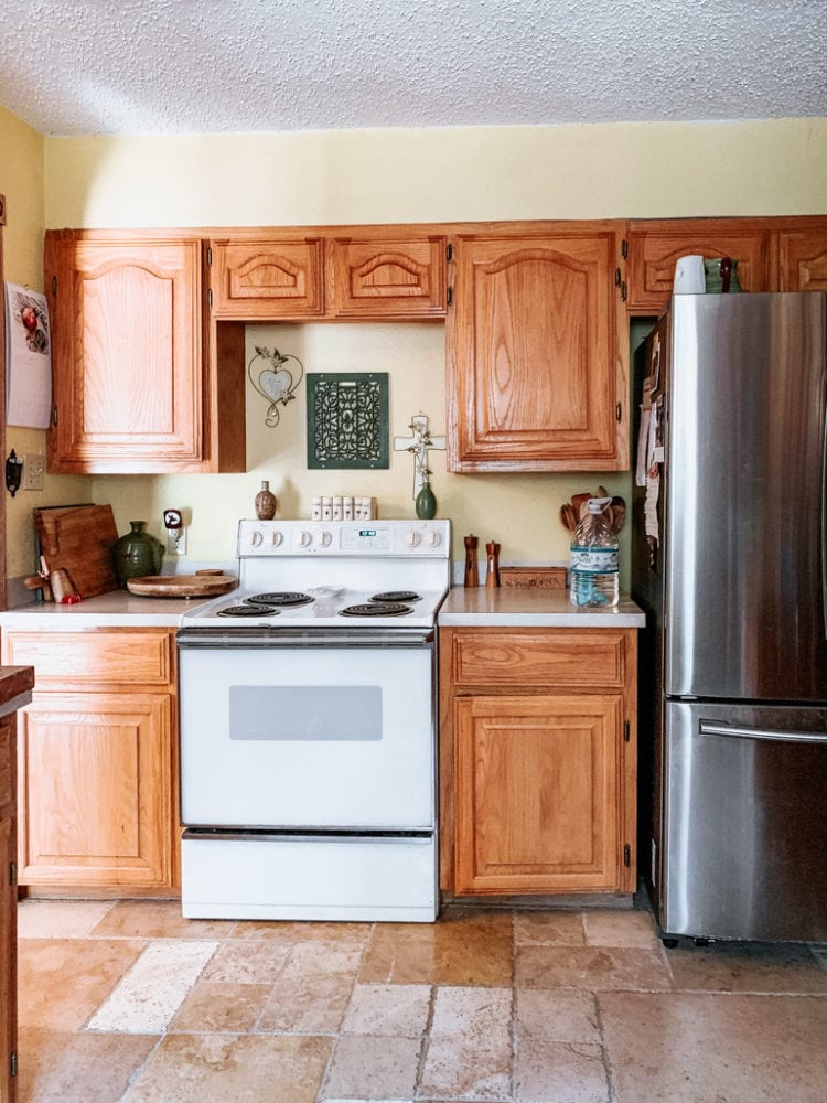 dated kitchen with light cabinetry and yellow walls 