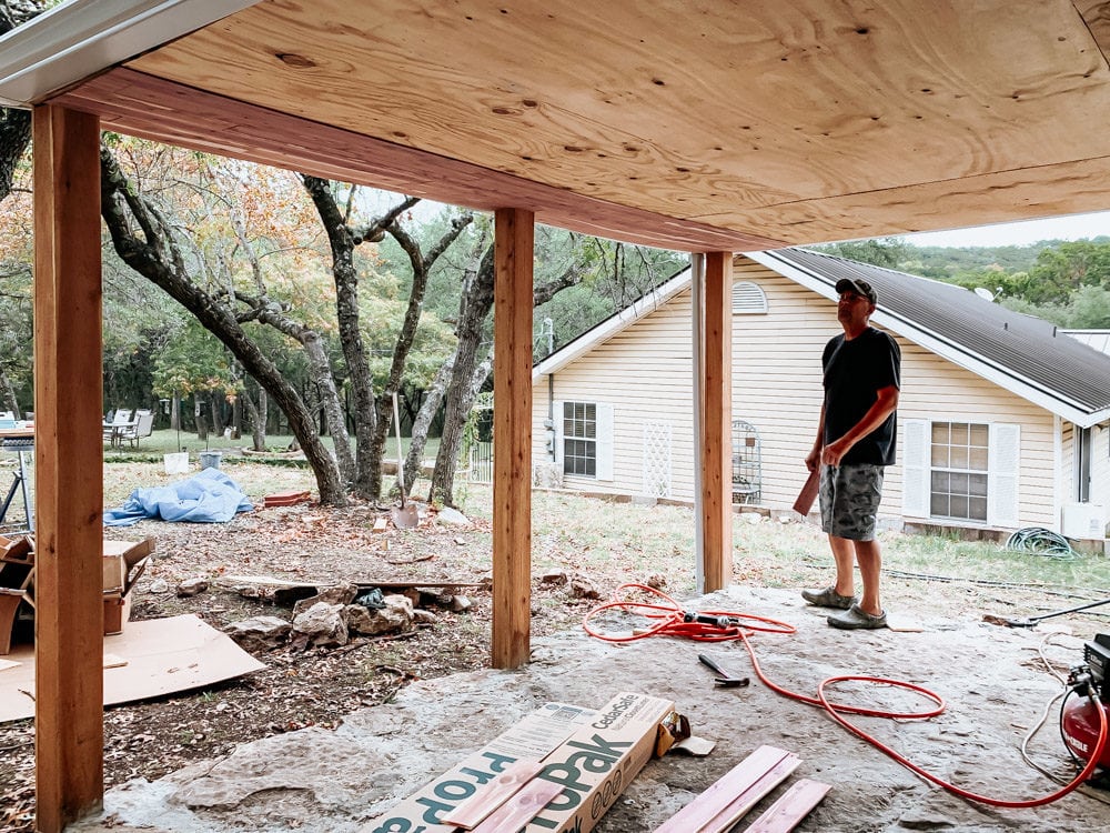 man installing cedar planks on ceiling