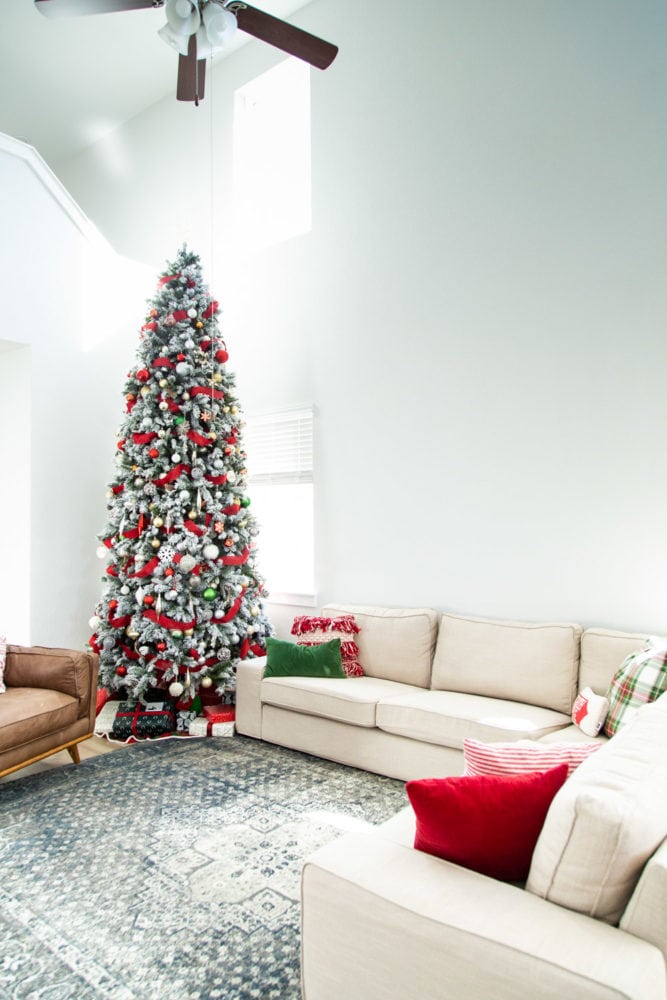 A living room with a large christmas tree 