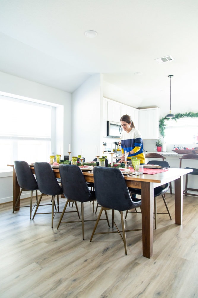 woman lighting a candle on a dining room table