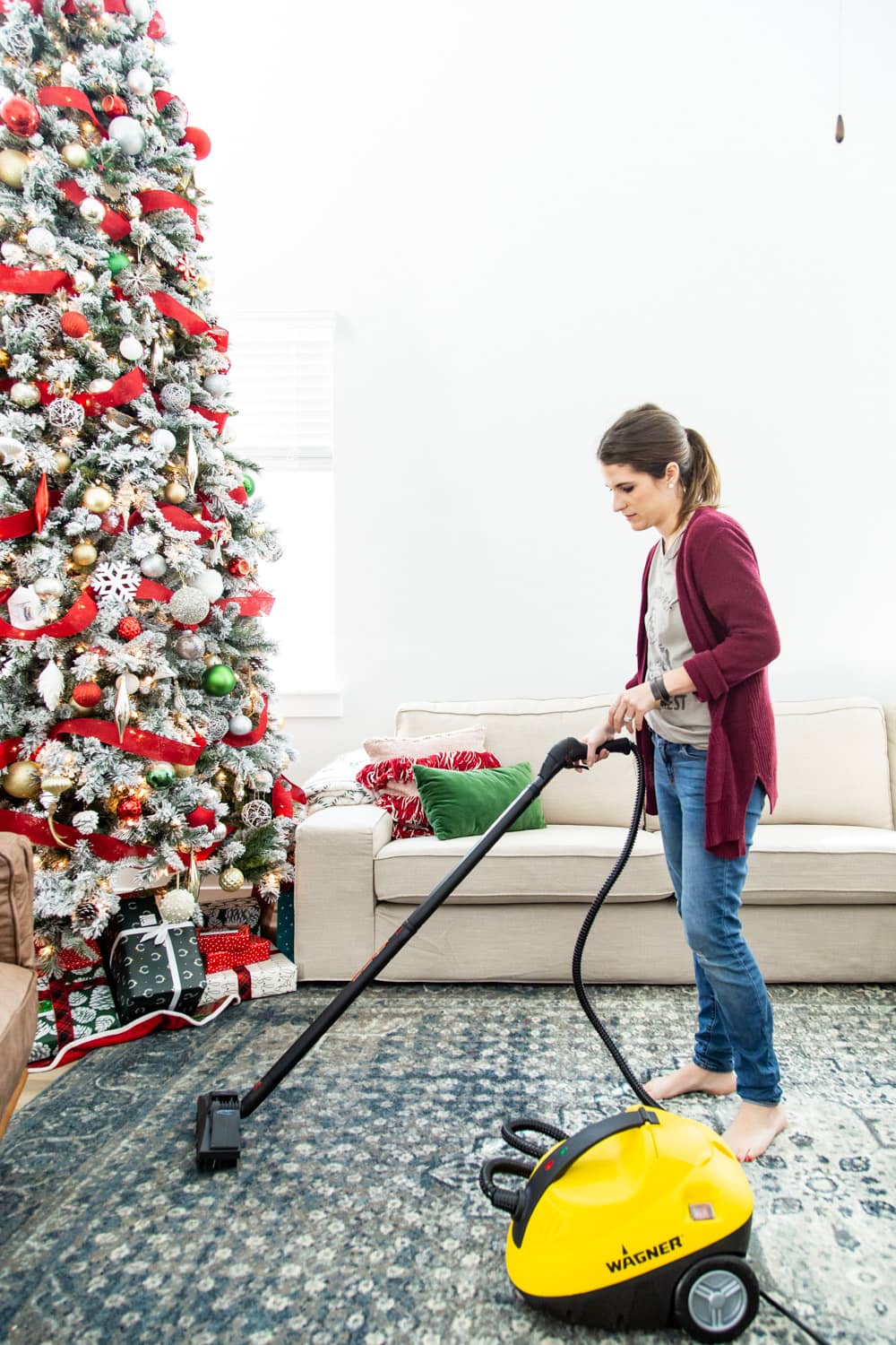 woman cleaning rug using a steamer