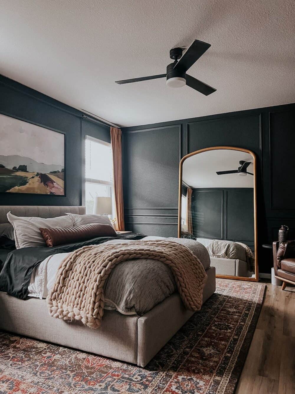 dark and moody master bedroom with a white bed and gold curtains