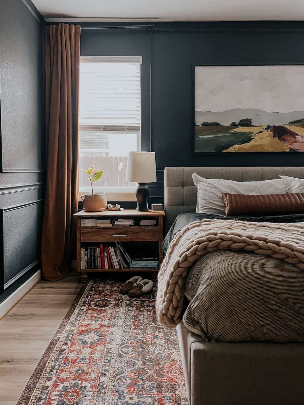 a bedroom with dark navy blue walls and a gold curtain