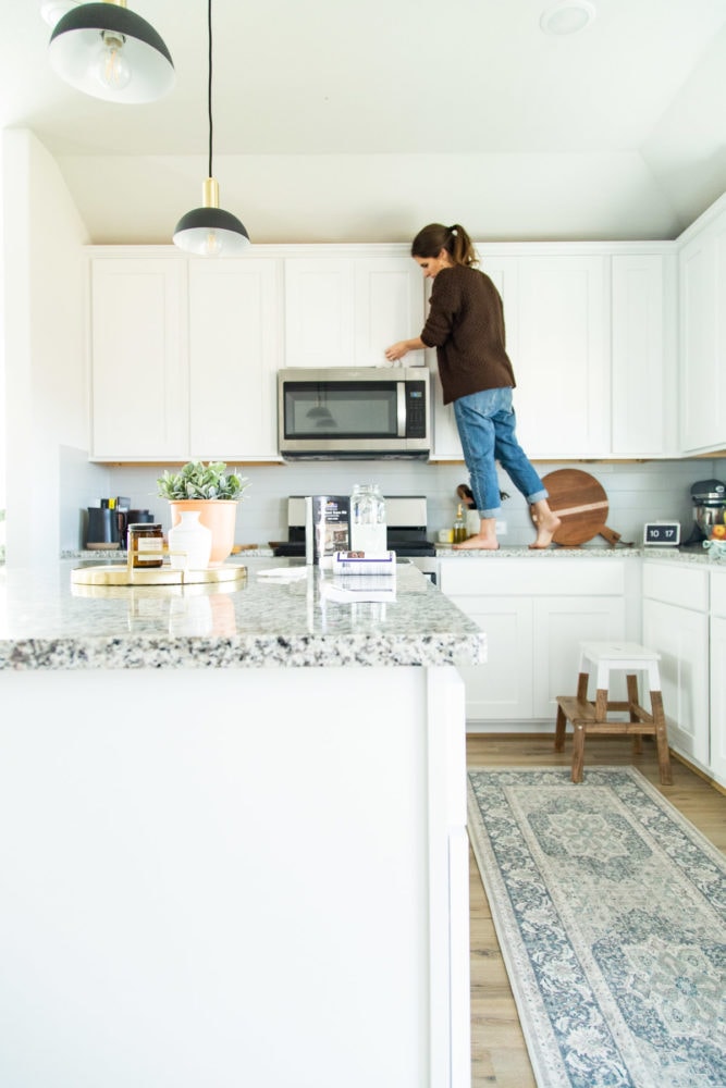 woman cleaning kitchen cabinets