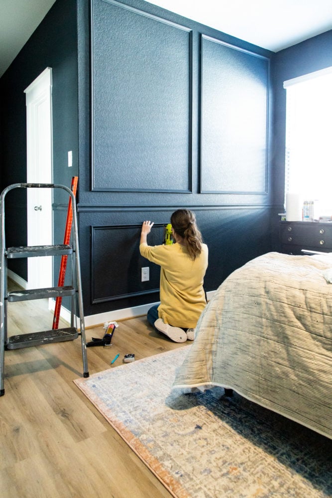 woman using a pin nailer on picture molding trim
