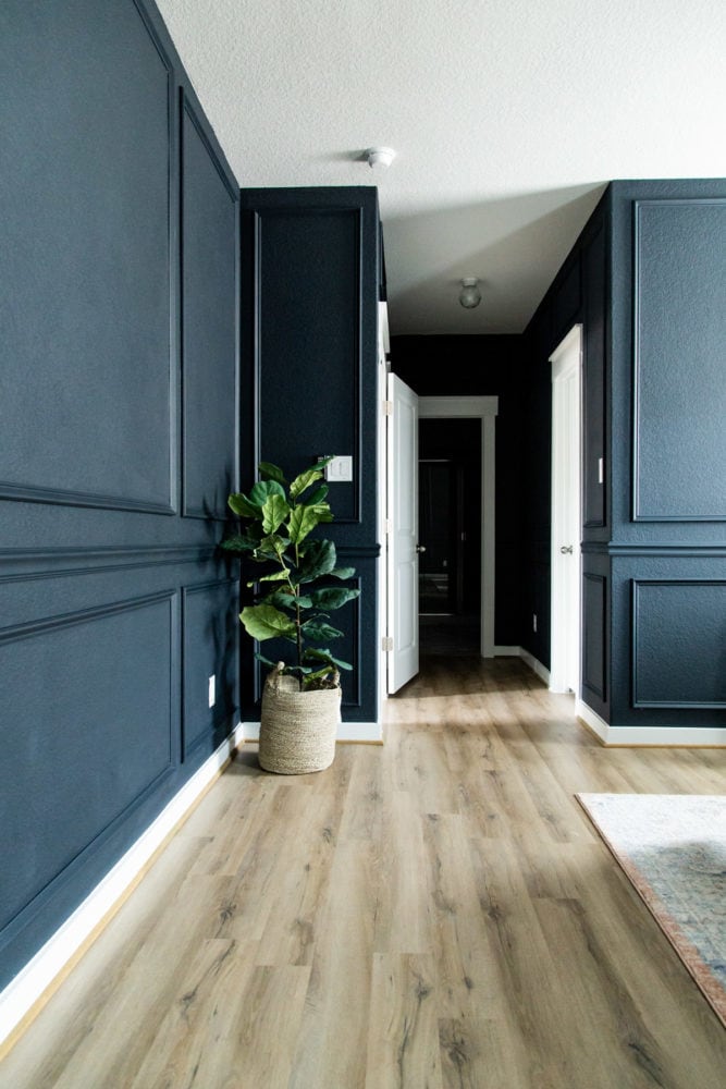 bedroom with dark blue walls and picture frame moulding