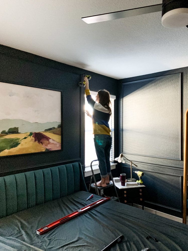 woman hanging a curtain rod