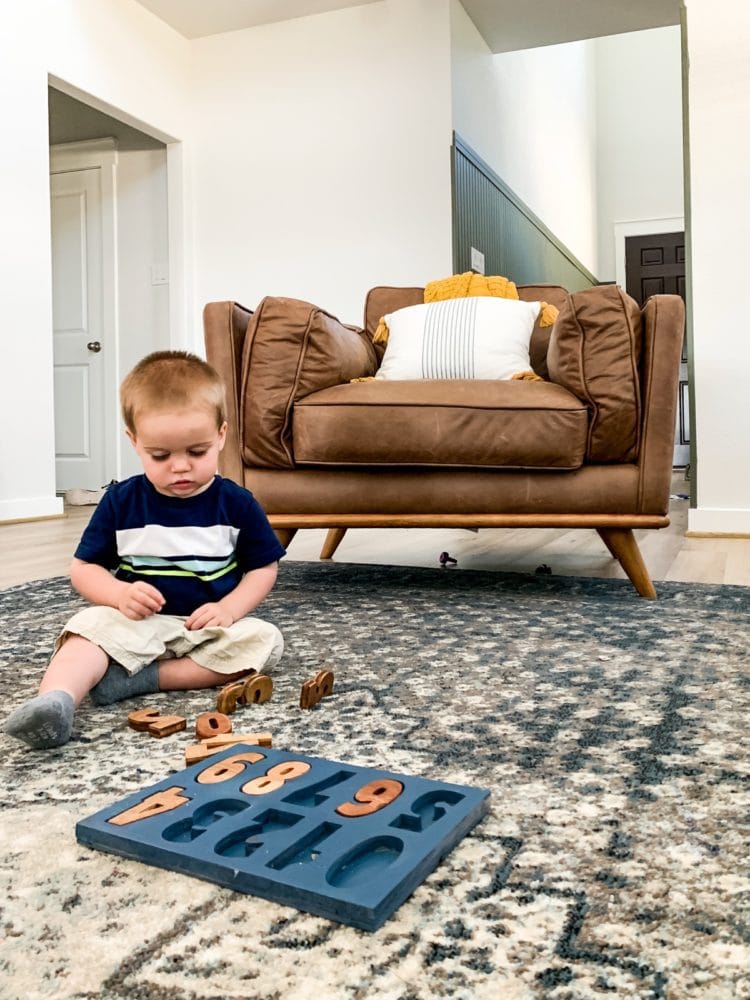 toddler playing with a DIY wood puzzle