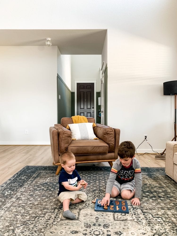 two young boys playing with a wood puzzle