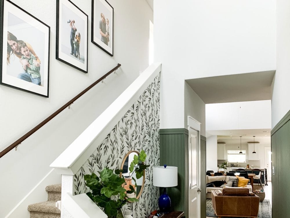 entry with dark beadboard paneling and floral wallpaper 