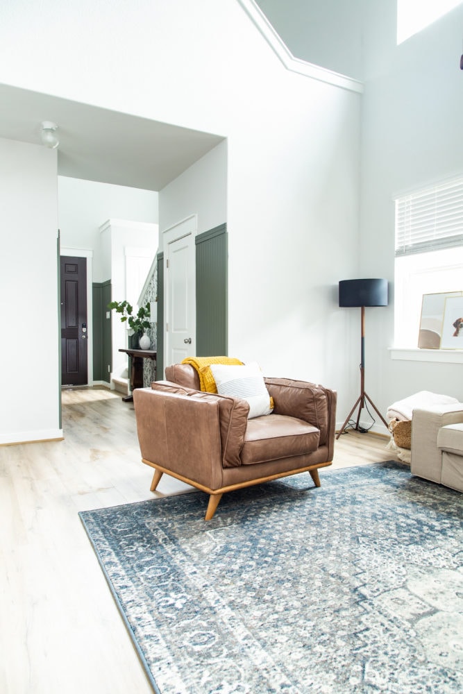 living room with view of entry with green paneling