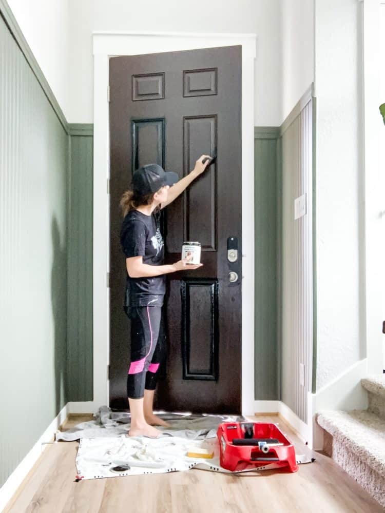 a woman painting a front door
