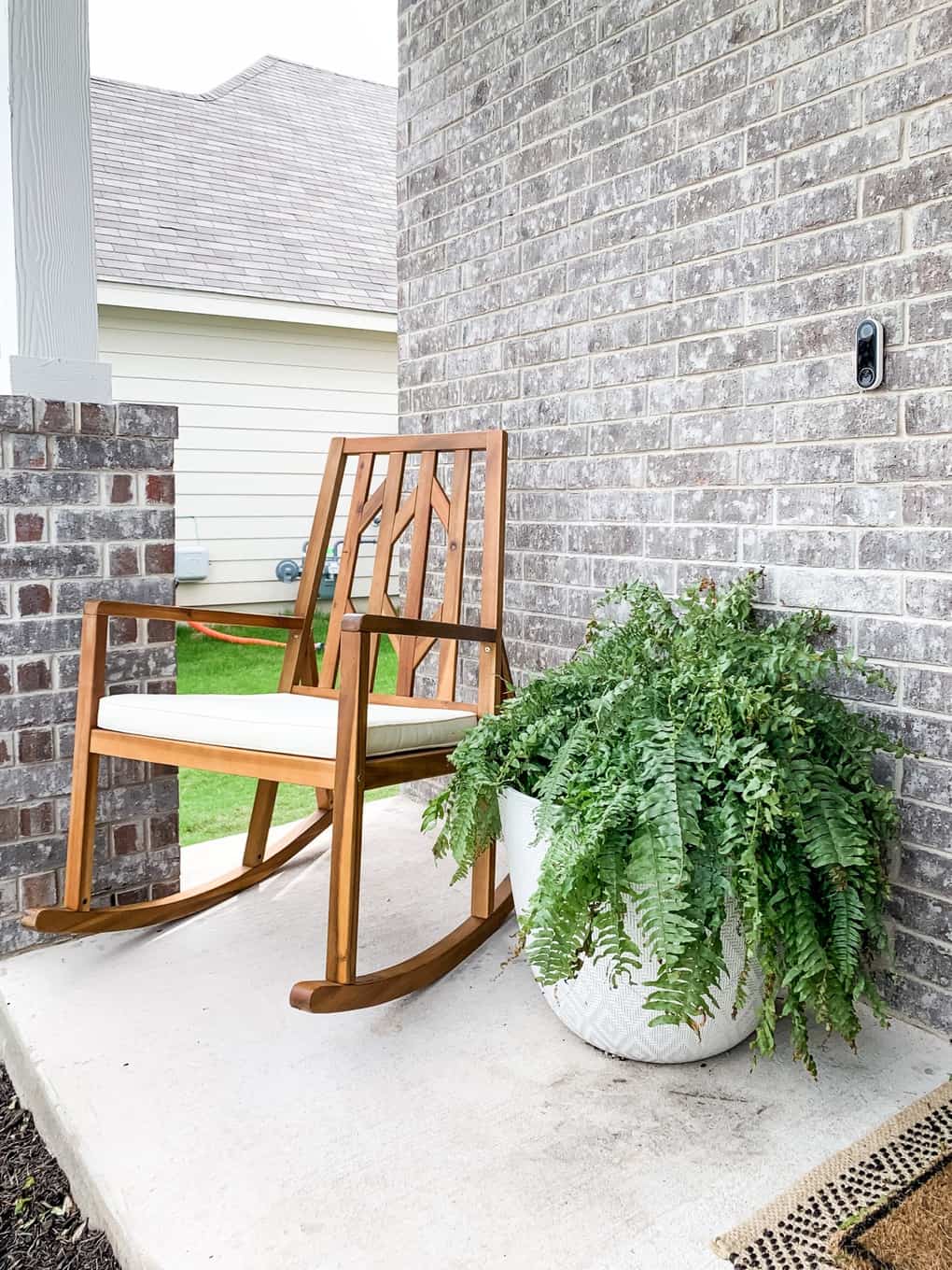 Front porch rocking chair and large fern