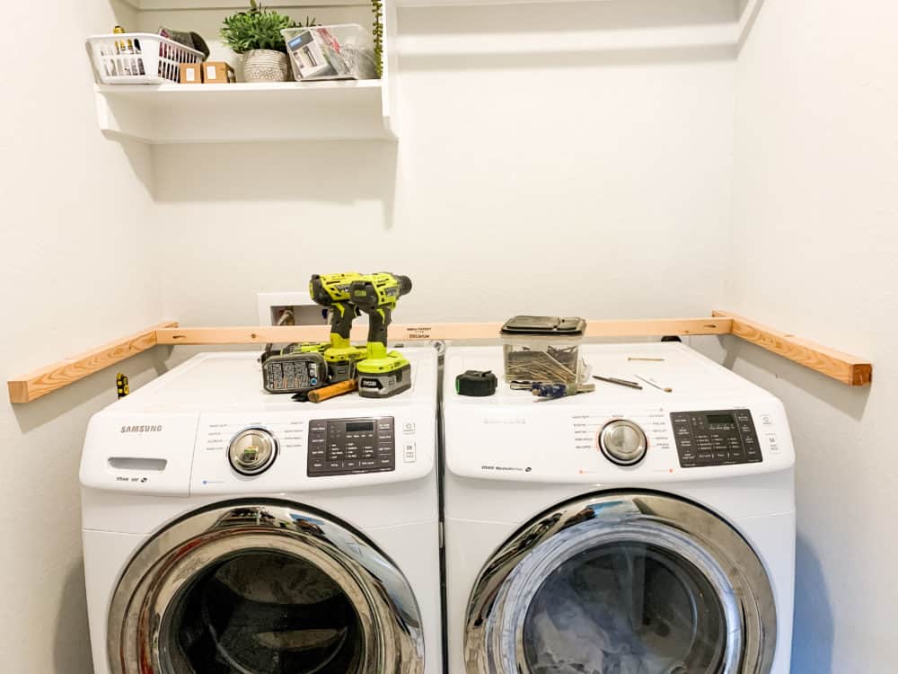 Side by side washer and dryer with ledger boards installed into walls for laundry room countertop 