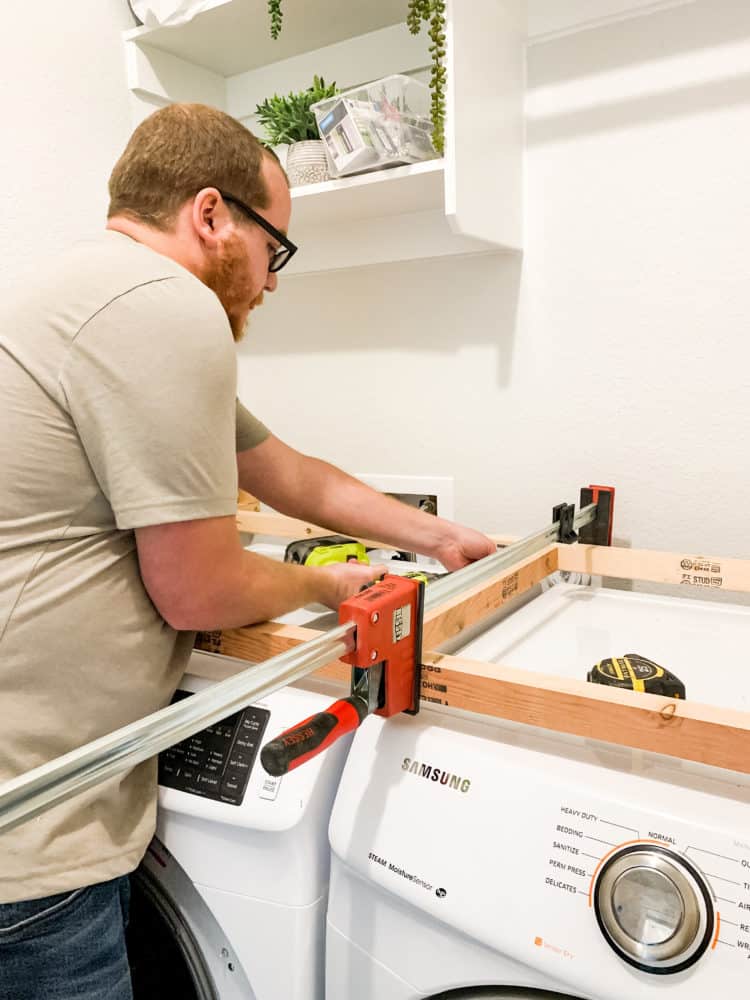 Man installing supports for laundry room countertop 