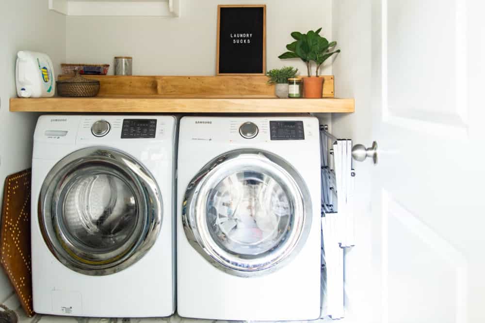 laundry room with side-by-side washer and dryer with a DIY wood countertop over them 