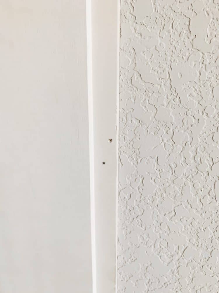 Close up of two nail holes in the lip of a shiplap board