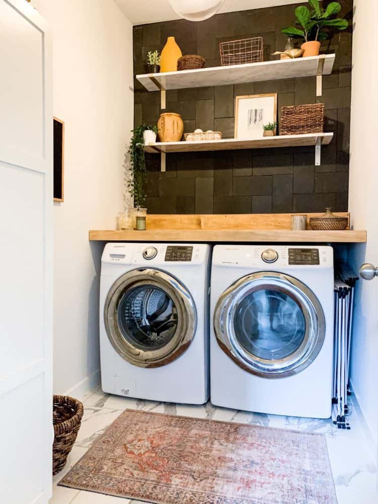 Laundry room with black tiled wall 