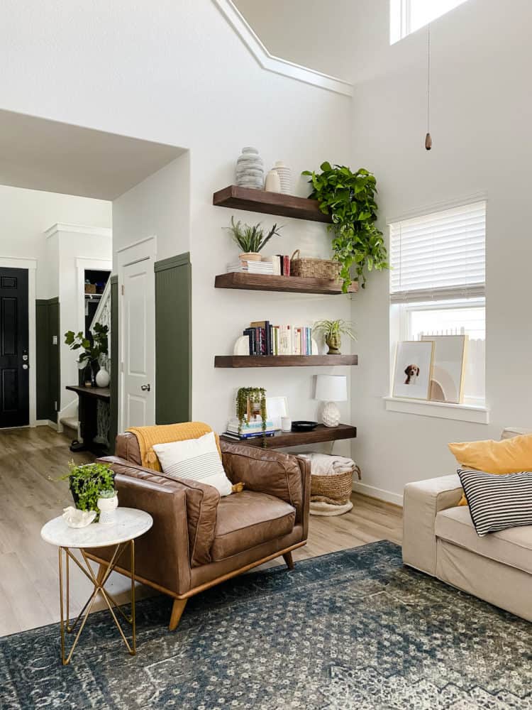corner of living room with a leather chair and floating wood sheles 