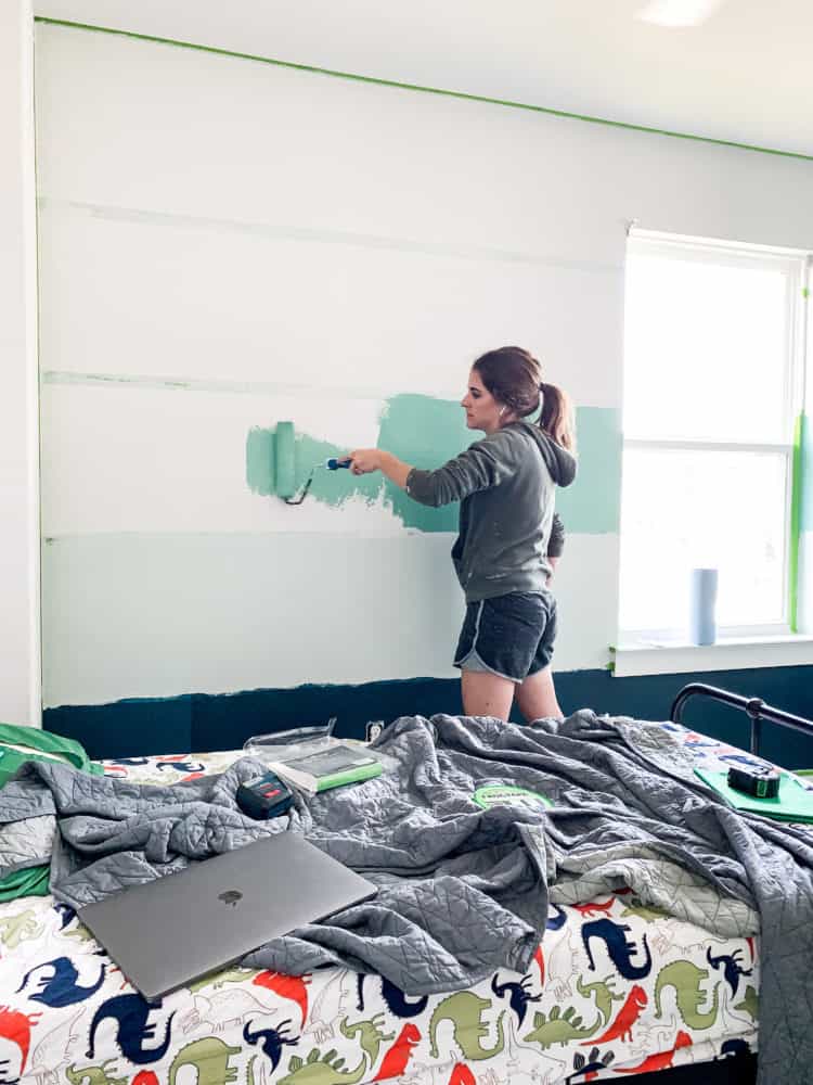 woman painting stripes on a wall