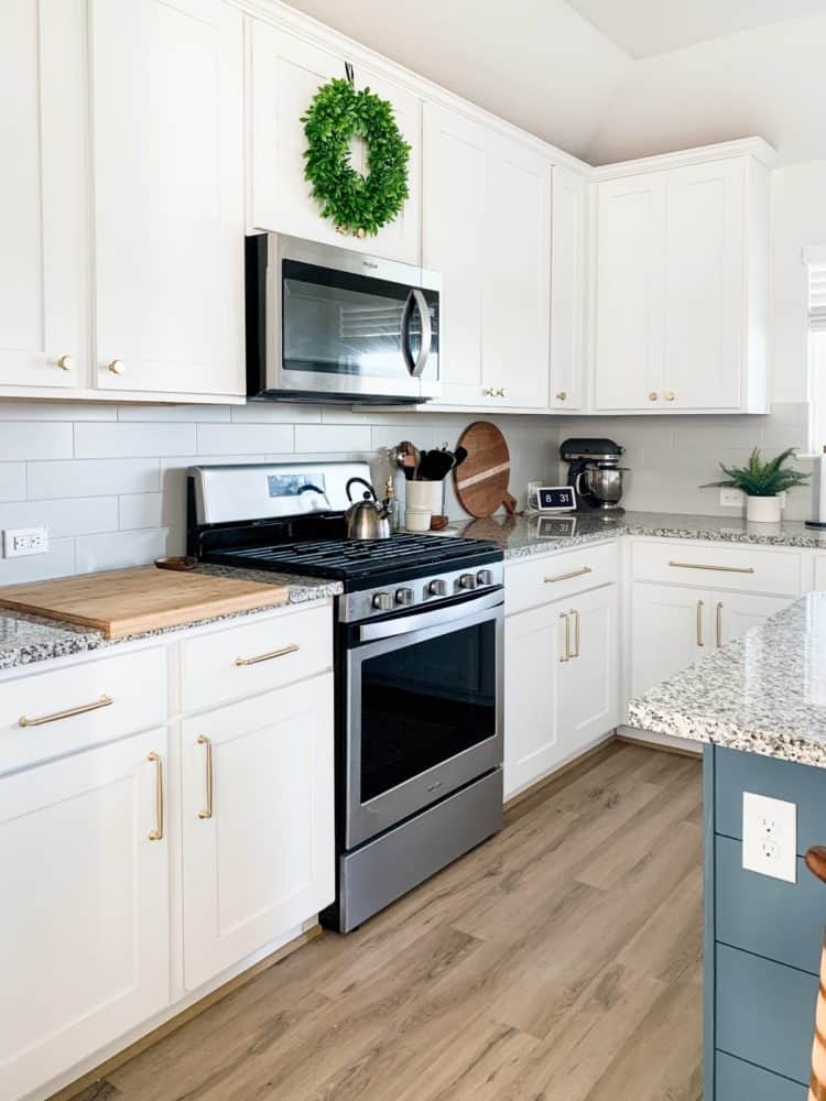 A white and gray kitchen with gold cabinet pulls 