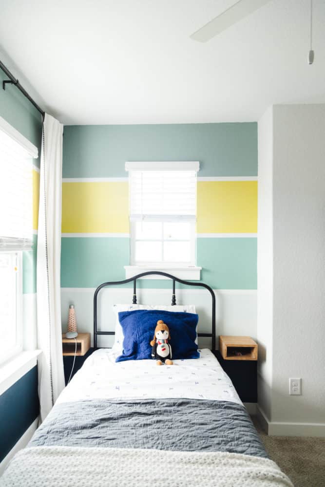 a child's room with stripes painted on the walls