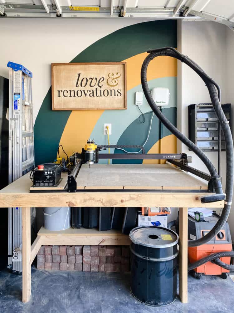 corner of garage with a colorful mural and a DIY carved wood sign 