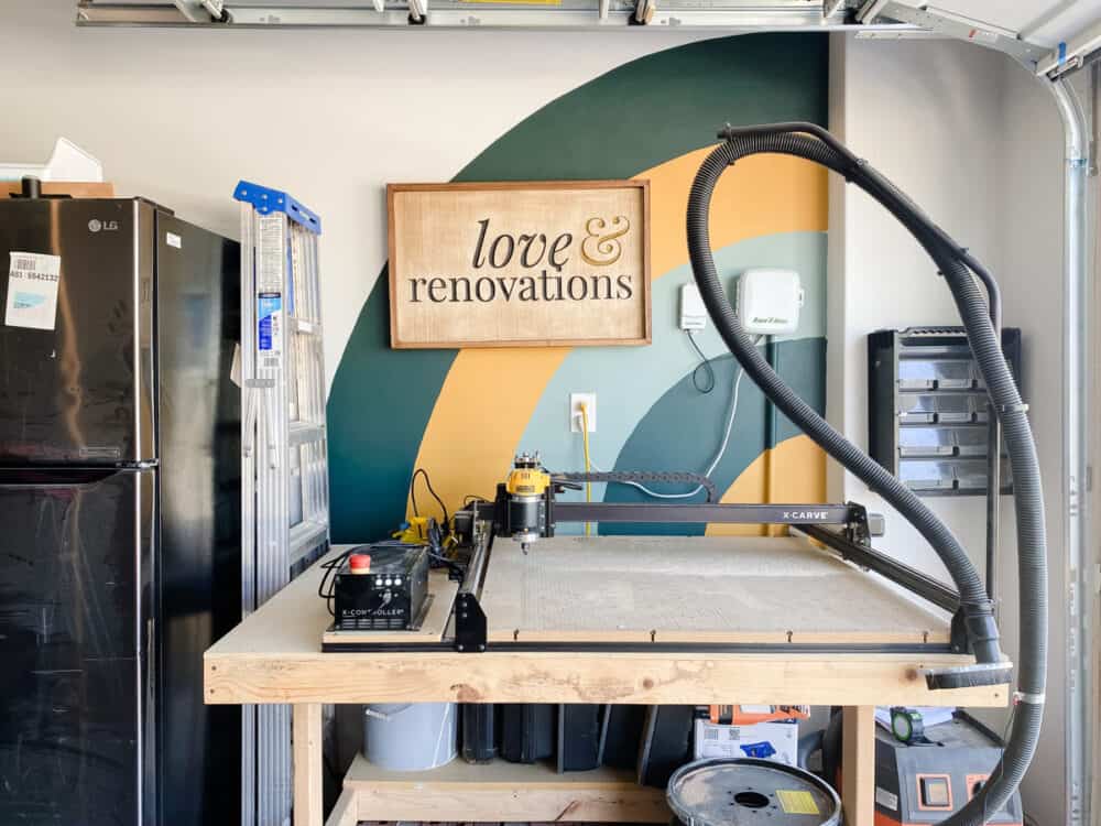 garage with an Inventables X-Carve, an arched mural, and a logo sign 