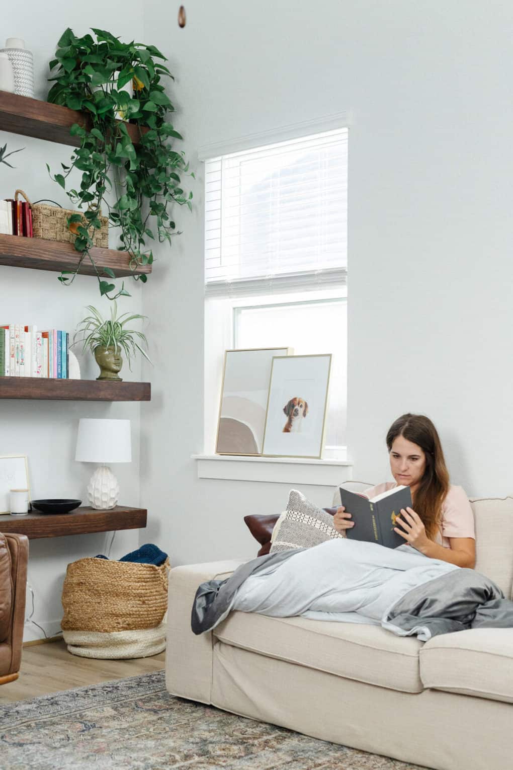 woman sitting on a couch with a weighted blanket 