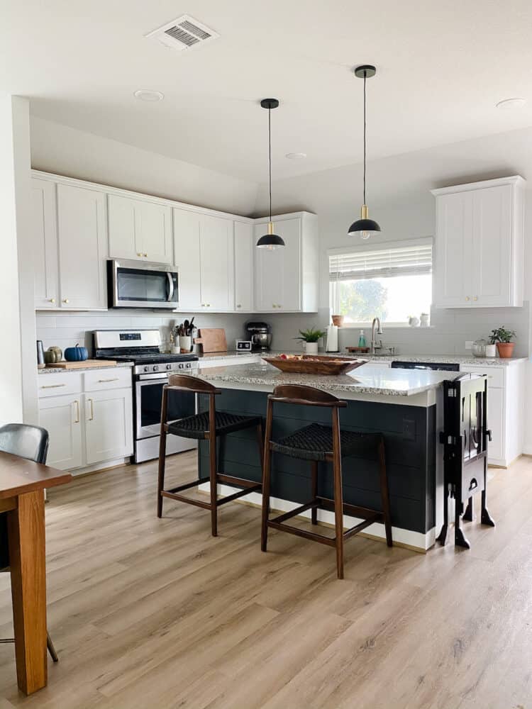 a white kitchen with a dark gray island