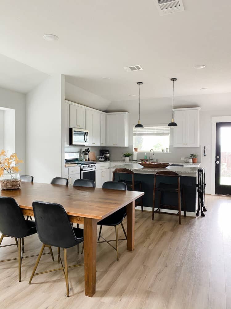 an open-concept living and dining room with a dark gray island