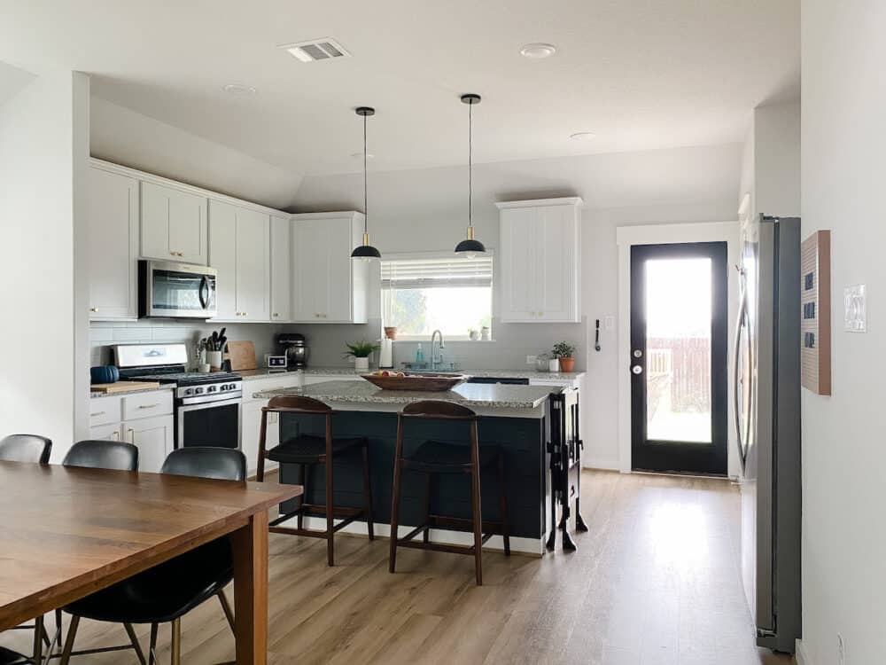 A white kitchen with a dark gray kitchen island