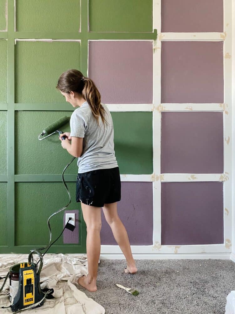 woman painting a wall using a power roller 