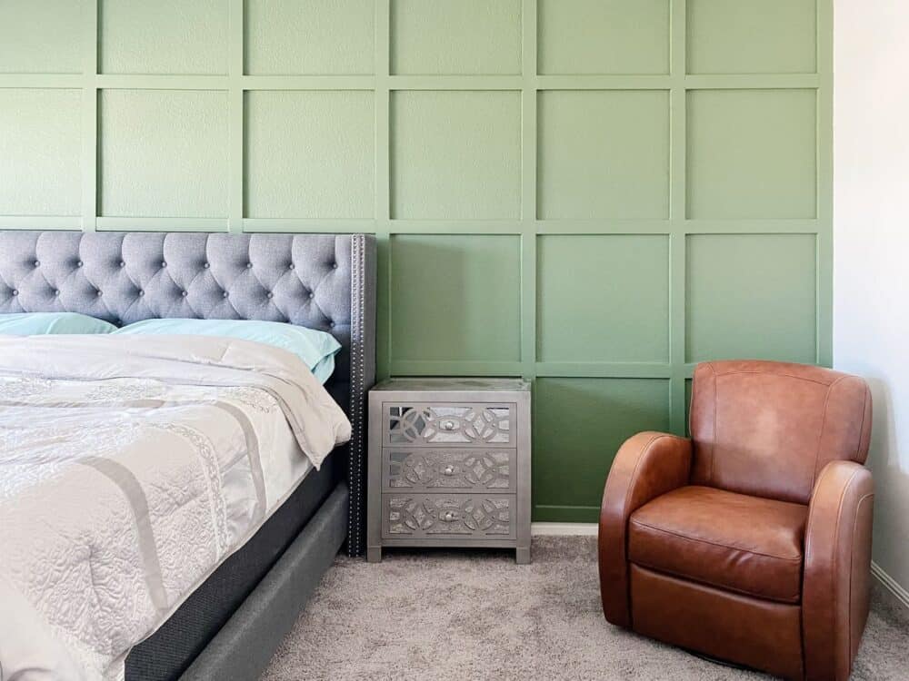 A bedroom with a green accent wall 