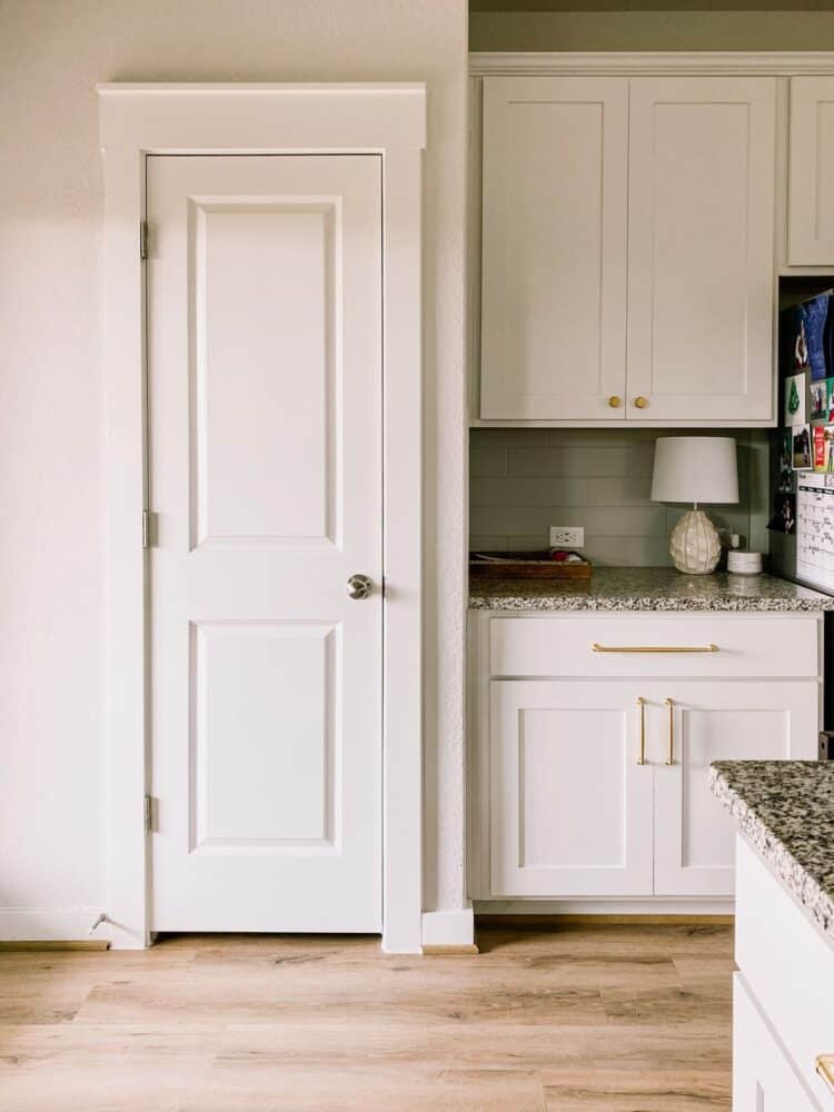 A kitchen closet with cabinets next to it 