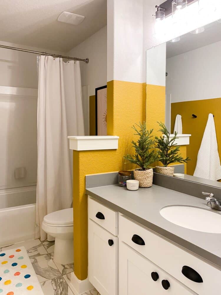 a small bathroom with yellow and white walls