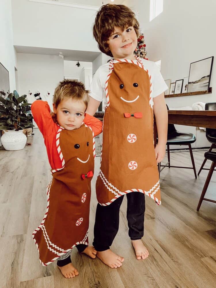 two young boys with gingerbread man aprons