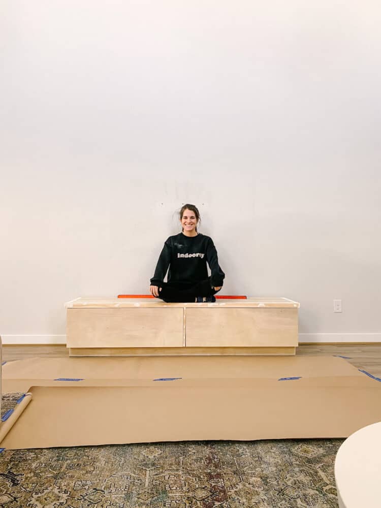 woman sitting on top of a DIY  raised fireplace hearth