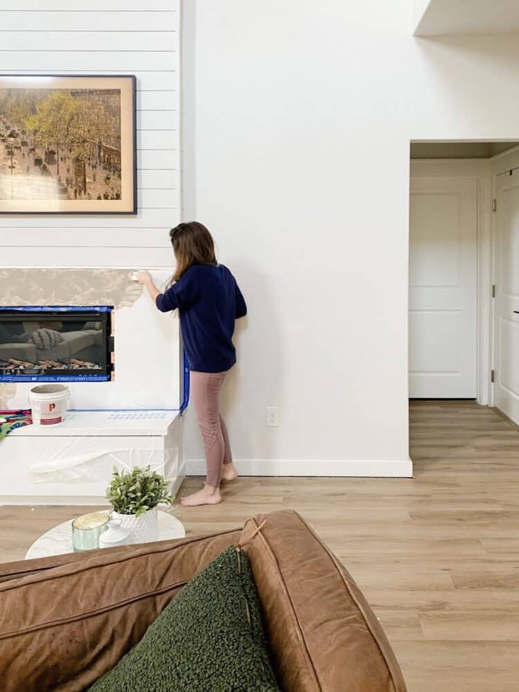 Woman applying Roman Clay to DIY fireplace 