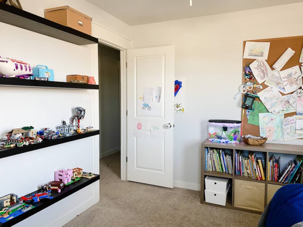 A kid bedroom with shelves on the wall