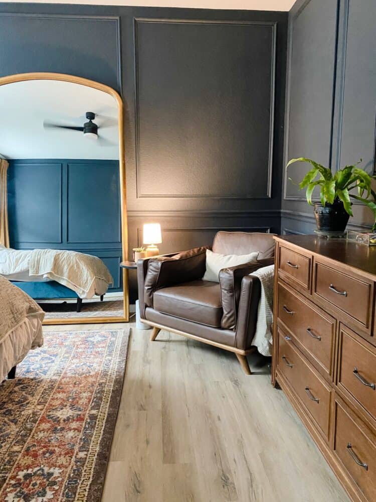 Cozy bedroom corner with a dark leather chair and a table with a lamp