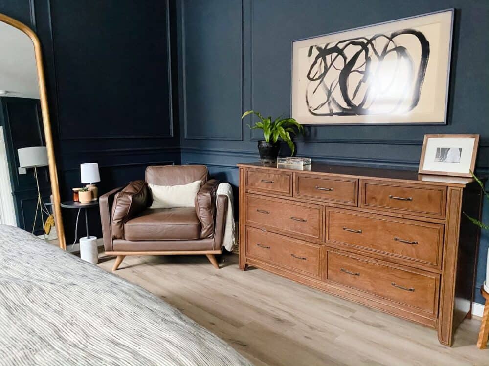 Bedroom with dark walls and a dark leather chair 