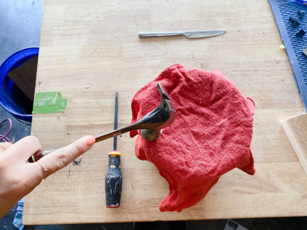 Woman using a hammer to close a paint can lid 