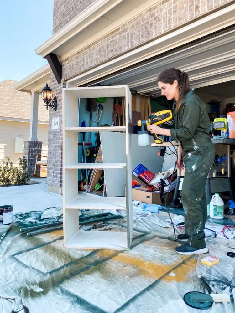 woman painting a DIY cubby system for entry. closet 