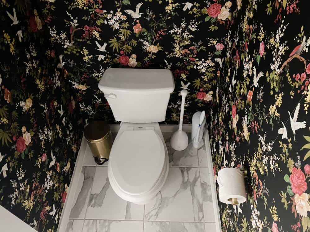 water closet with black floral wallpaper 