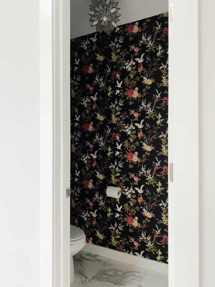 small water closet with black floral wallpaper 